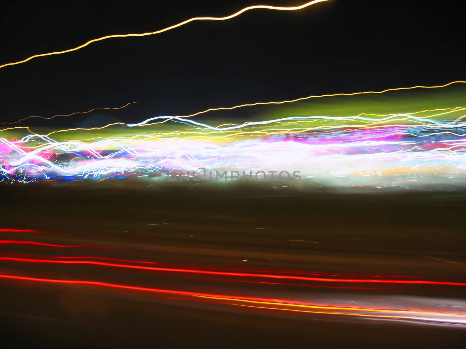 Abstract light trails captured from cars, signs, and other landmarks.