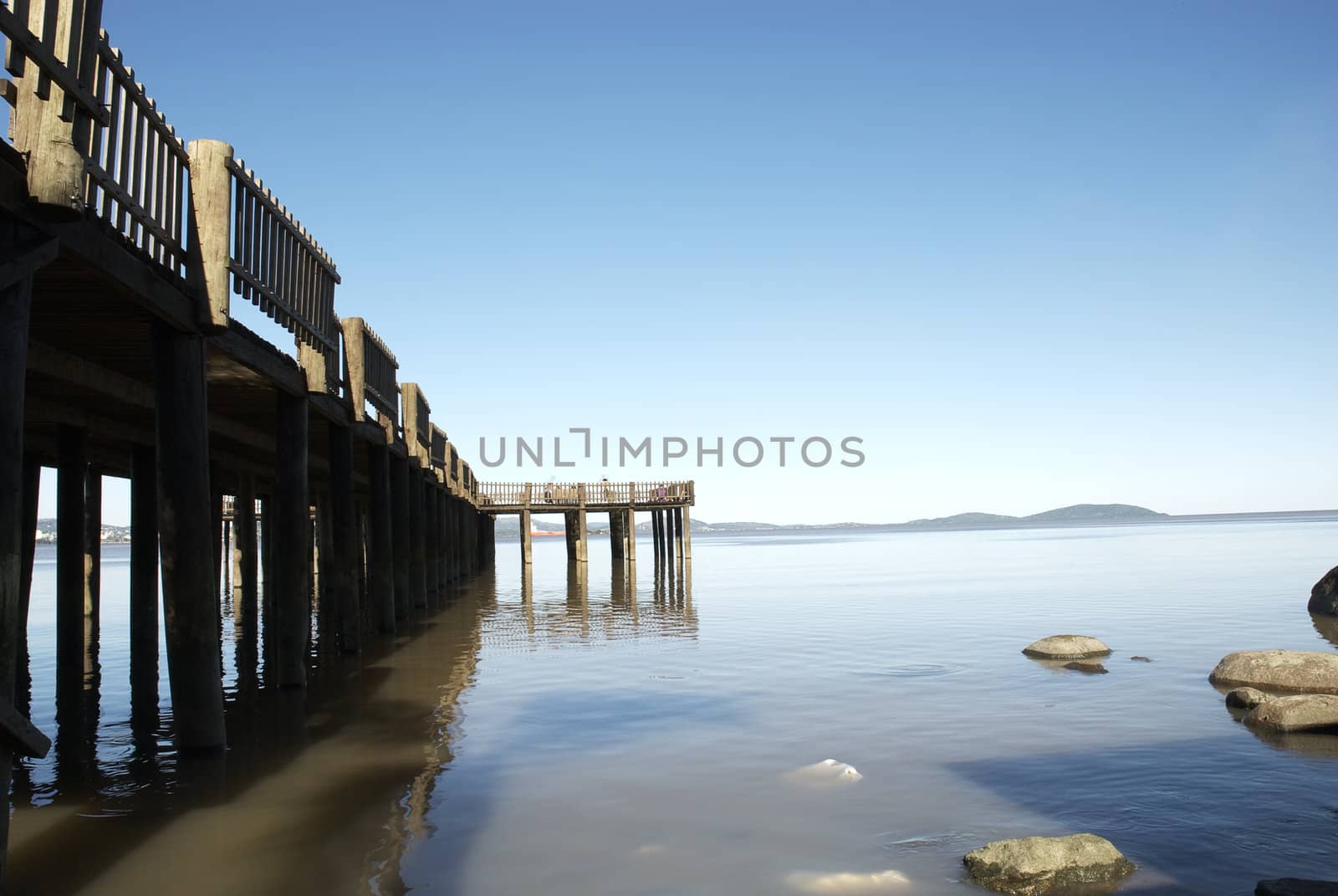 Wooden pier over calm lake, with loads of copy space