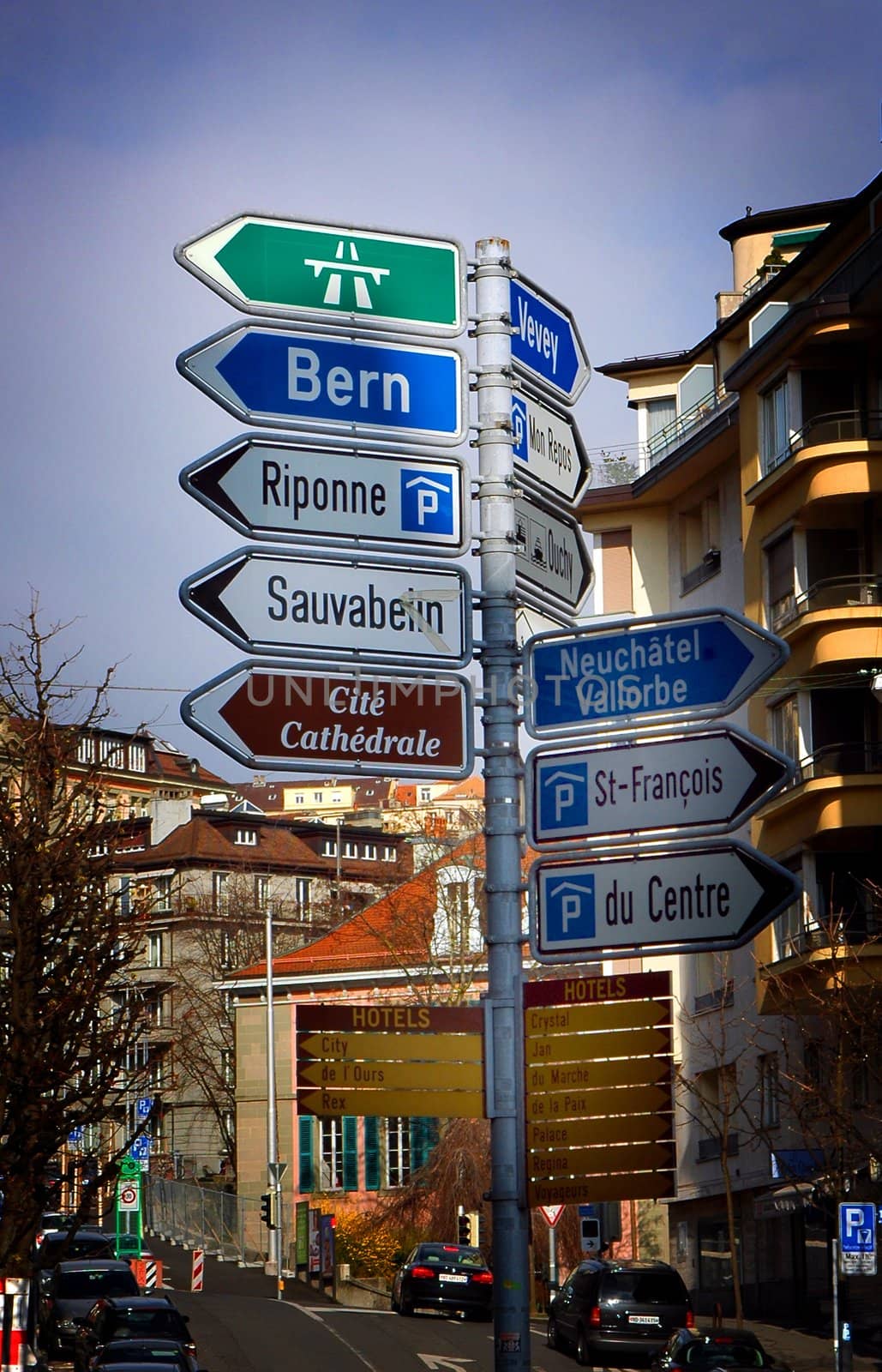 Various directional street signs on one post within Lausanne, Switzerland.
