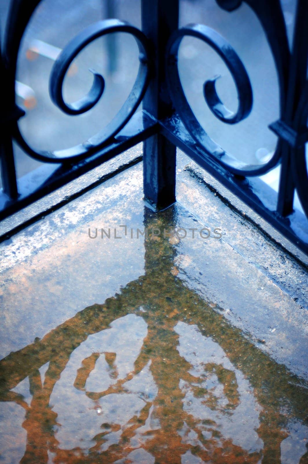 Close up image of iron work on Hotel balcony corner railing in the rain.