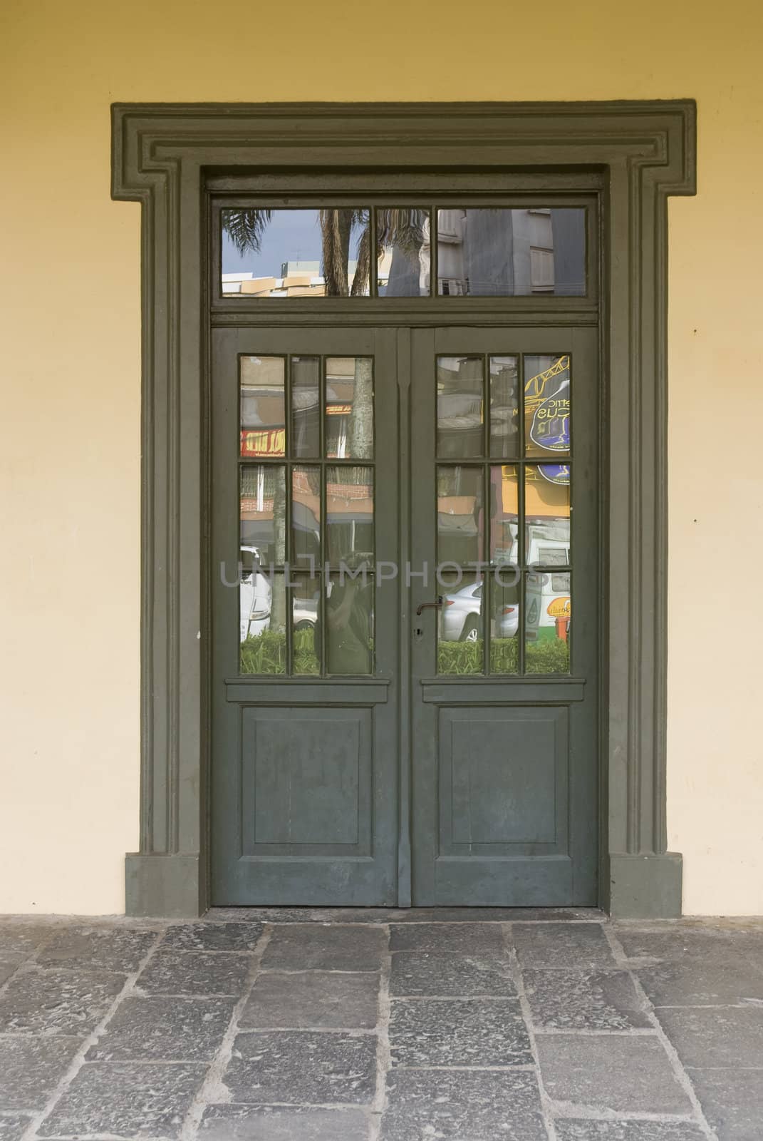 Front shot of a rustic brown wooden door, with cream coloured wall.