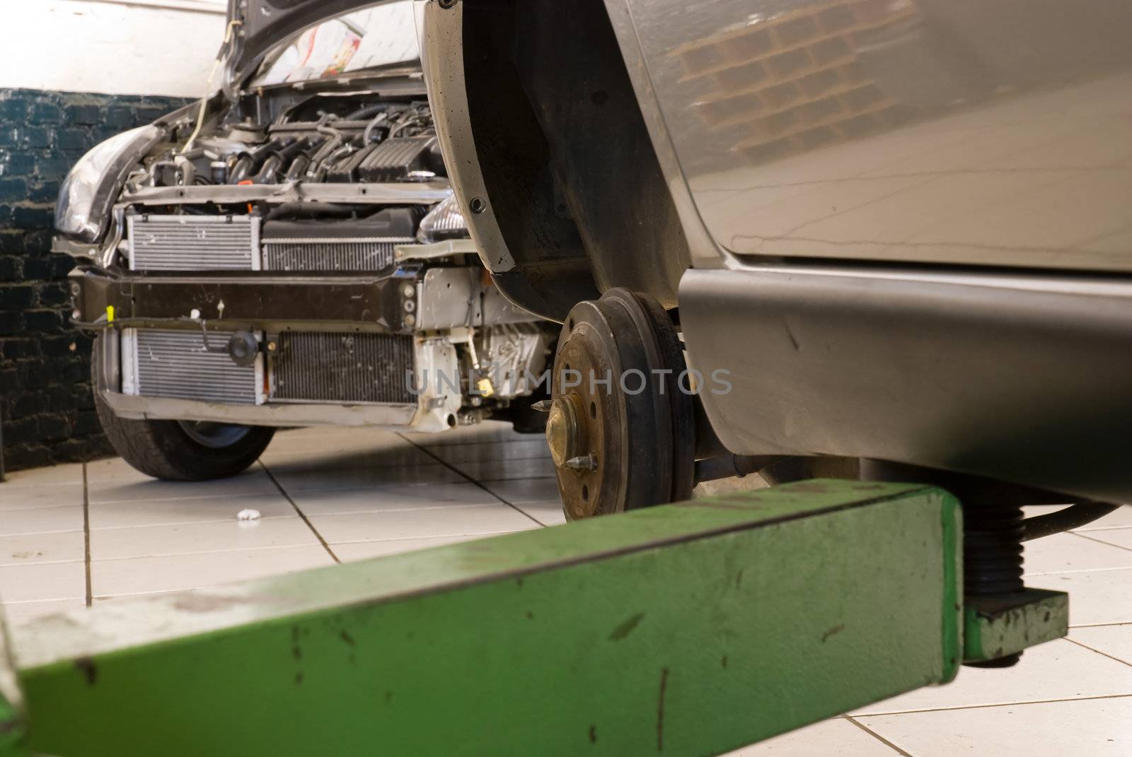 Detail shot of a car without wheels lifted by a repair shop lift
