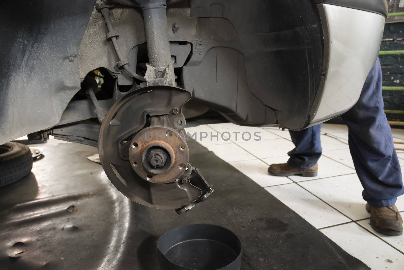 Detail shot of a car without wheels lifted by a repair shop lift