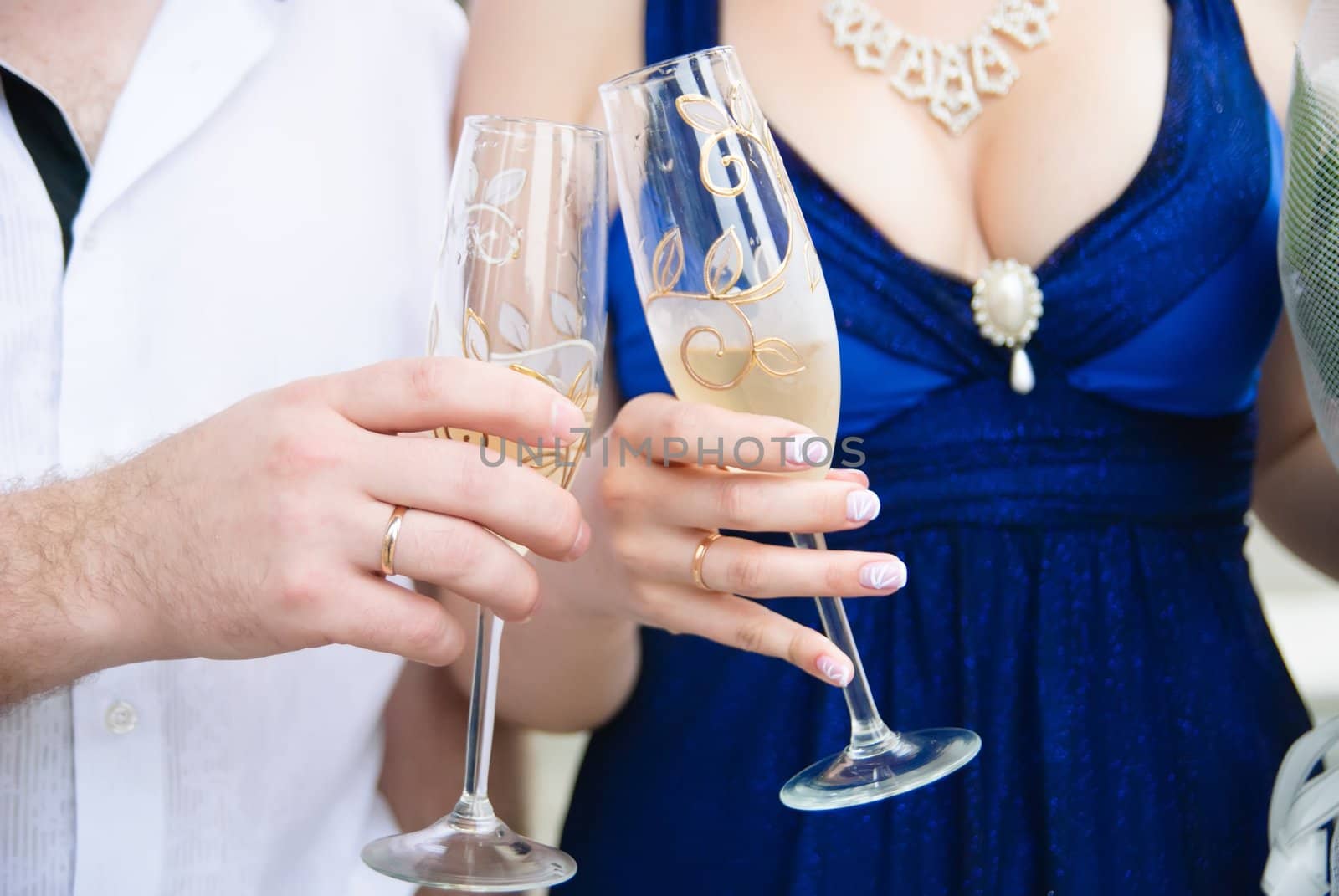 Bride and groom holding wedding glasses with champagne