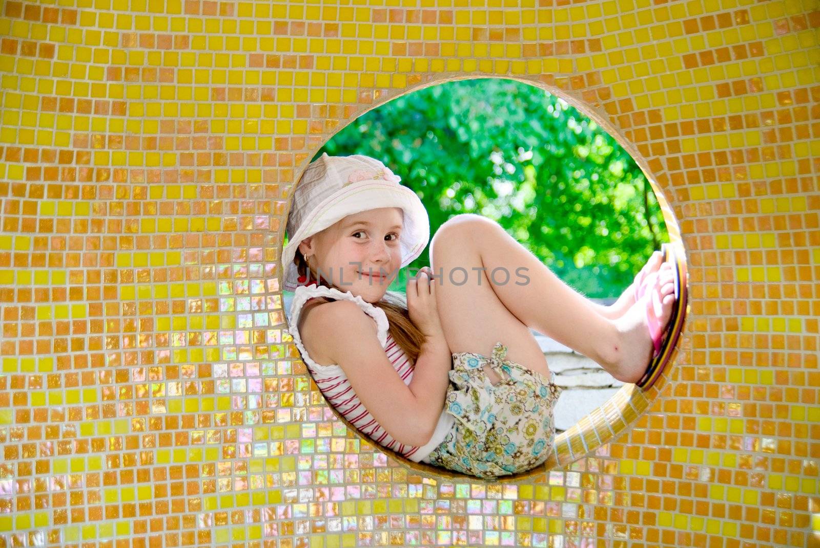 Little girl sitting in the round window