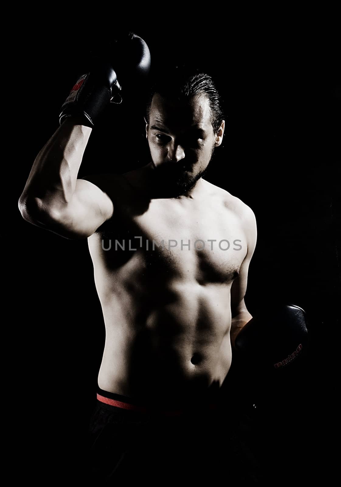 Muscular boxer over black background