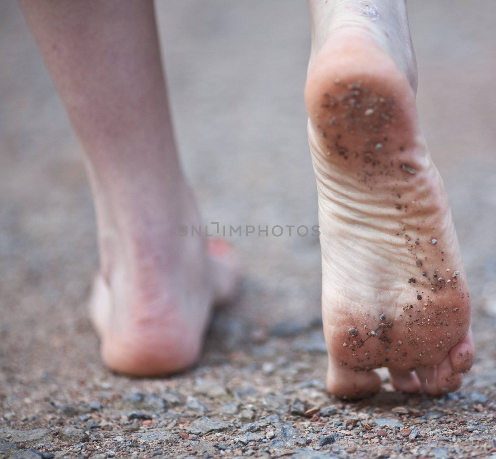 Woman walking over stones, barefoot