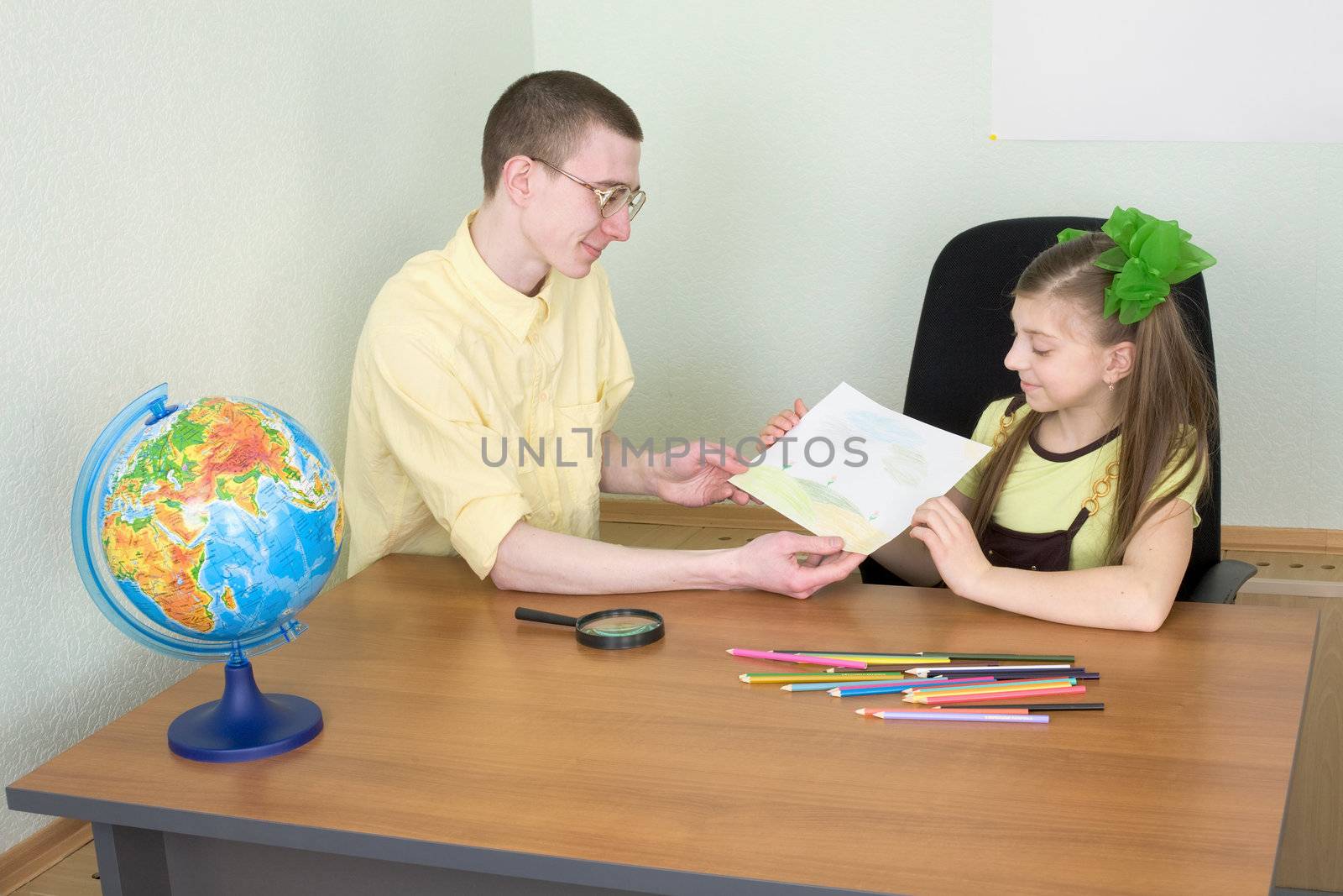 The girl shows new drawing to the brother