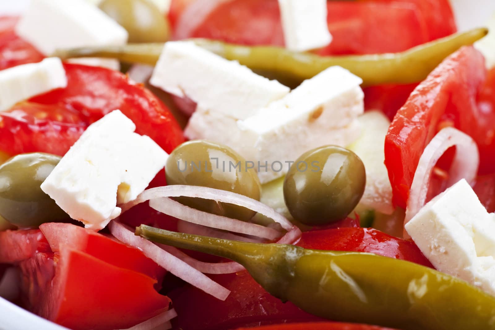 detail of a greek salad on a white plate