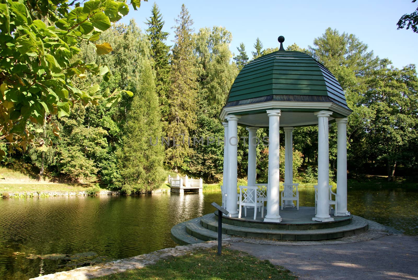 Arbour on a background of a pond and trees