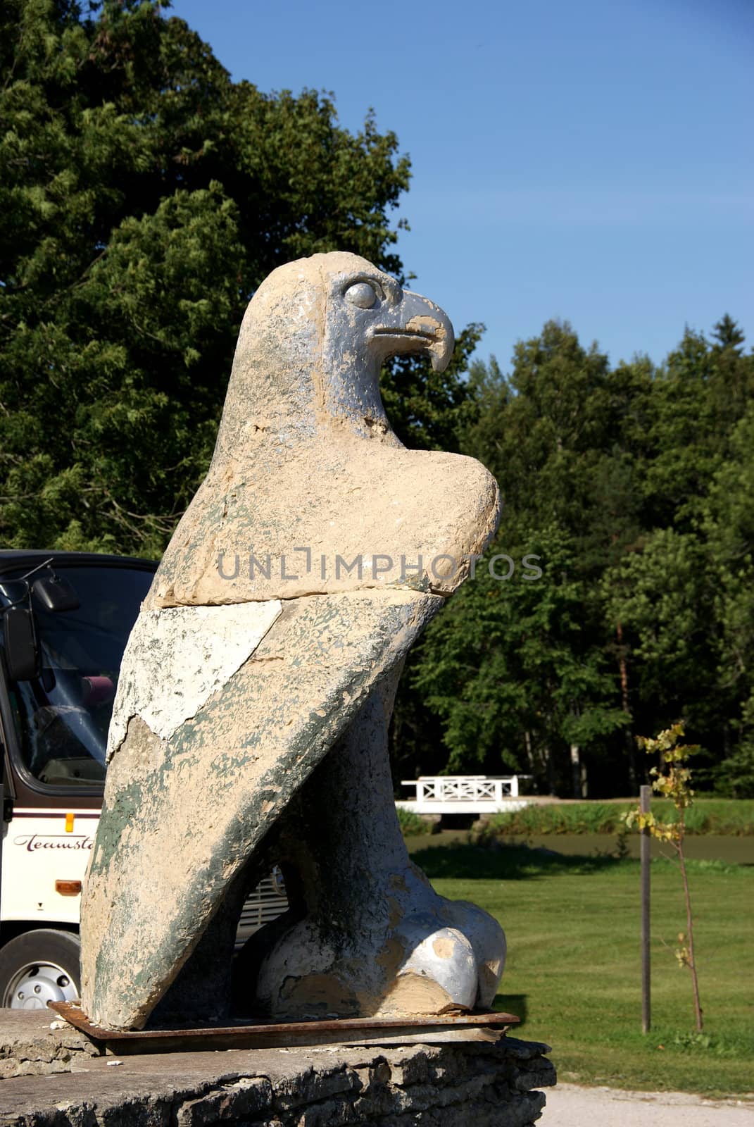 Stone sculpture of an eagle on a background of trees