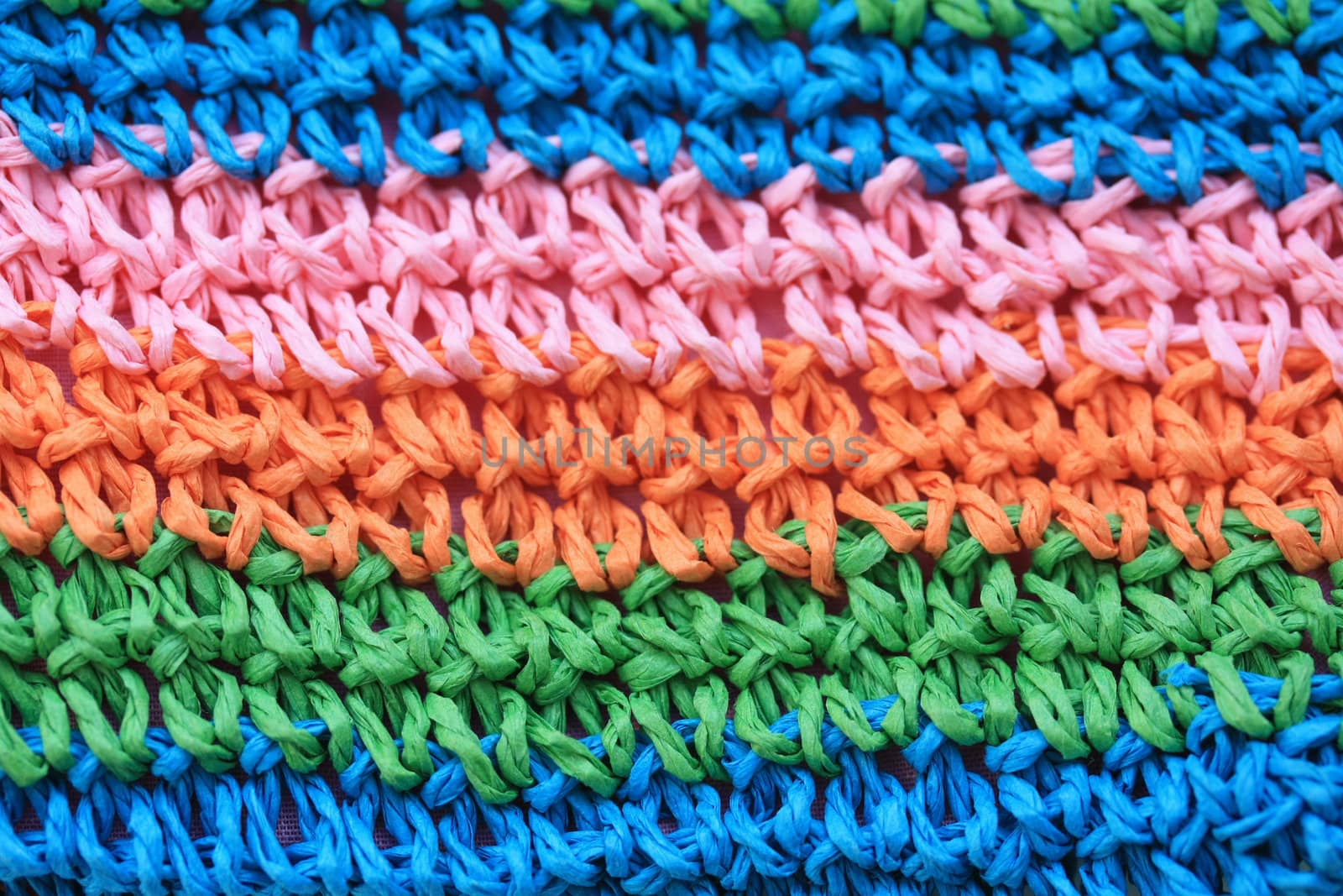 Knitting texture background in green, orange, pink and blue