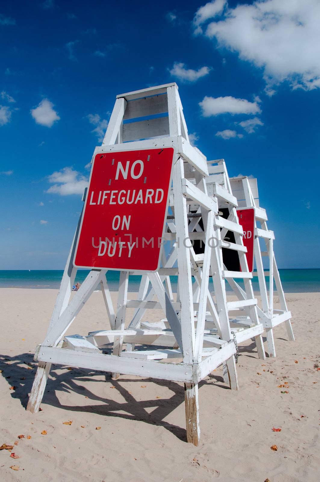 Empty lifeguard tower chair with not on duty sign