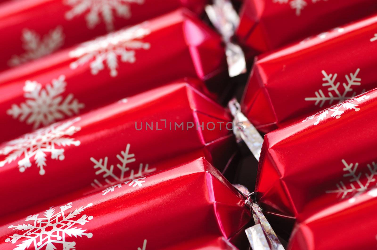 Closeup of many red Christmas crackers in a row