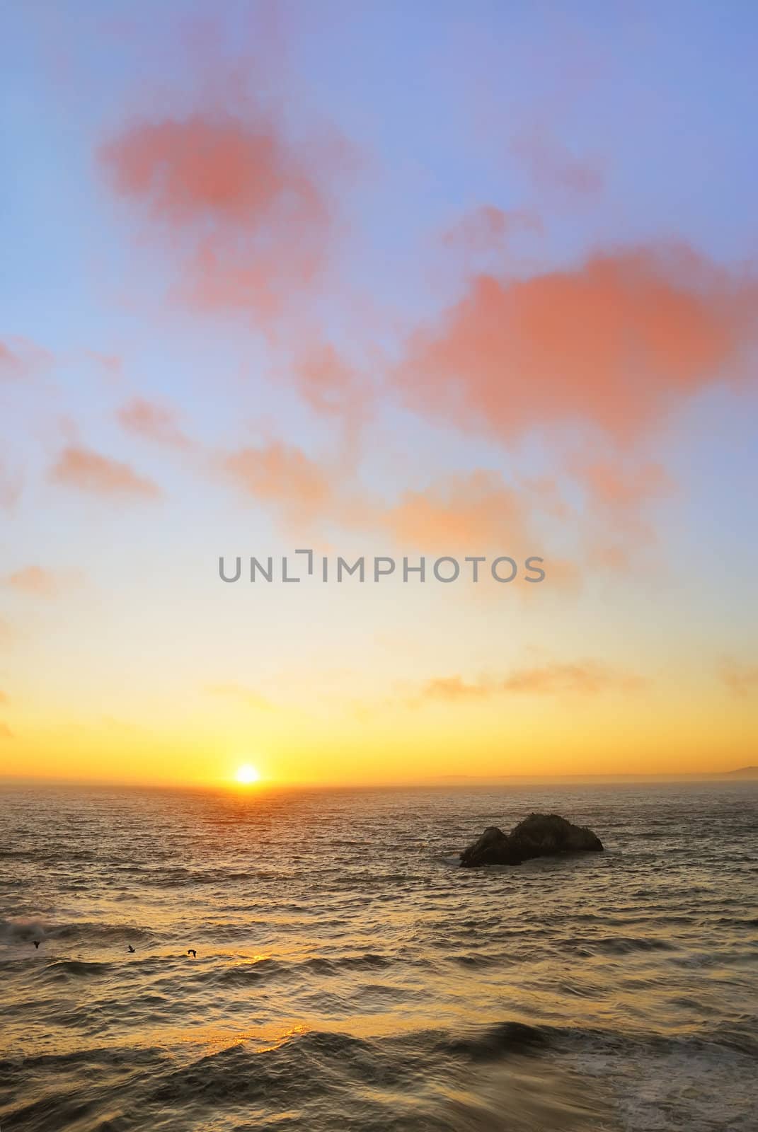 Sunset above the wavy Pacific as seen from the Ocean Beach in San Francisco, California.
