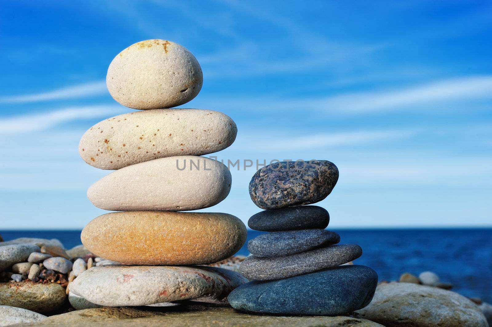 Massive boulders of different colors one on another, against the sky