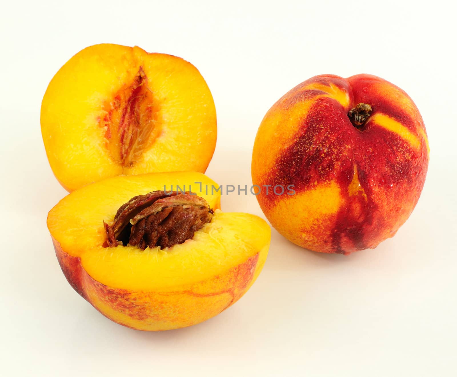 Juicy fresh nectarines, whole and cut, over white background