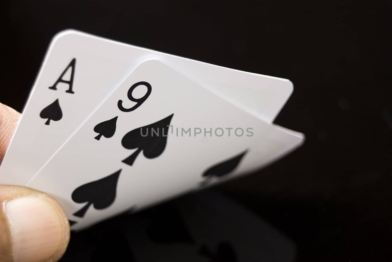 Lucky Nine cards held by hand against black background