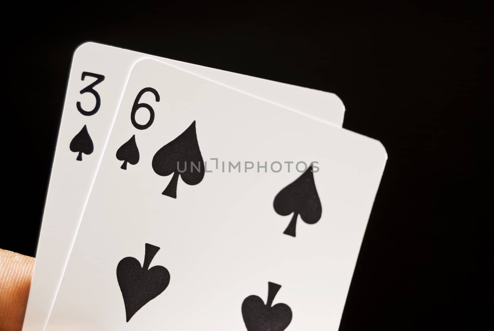 Lucky Nine cards held by hand against black background