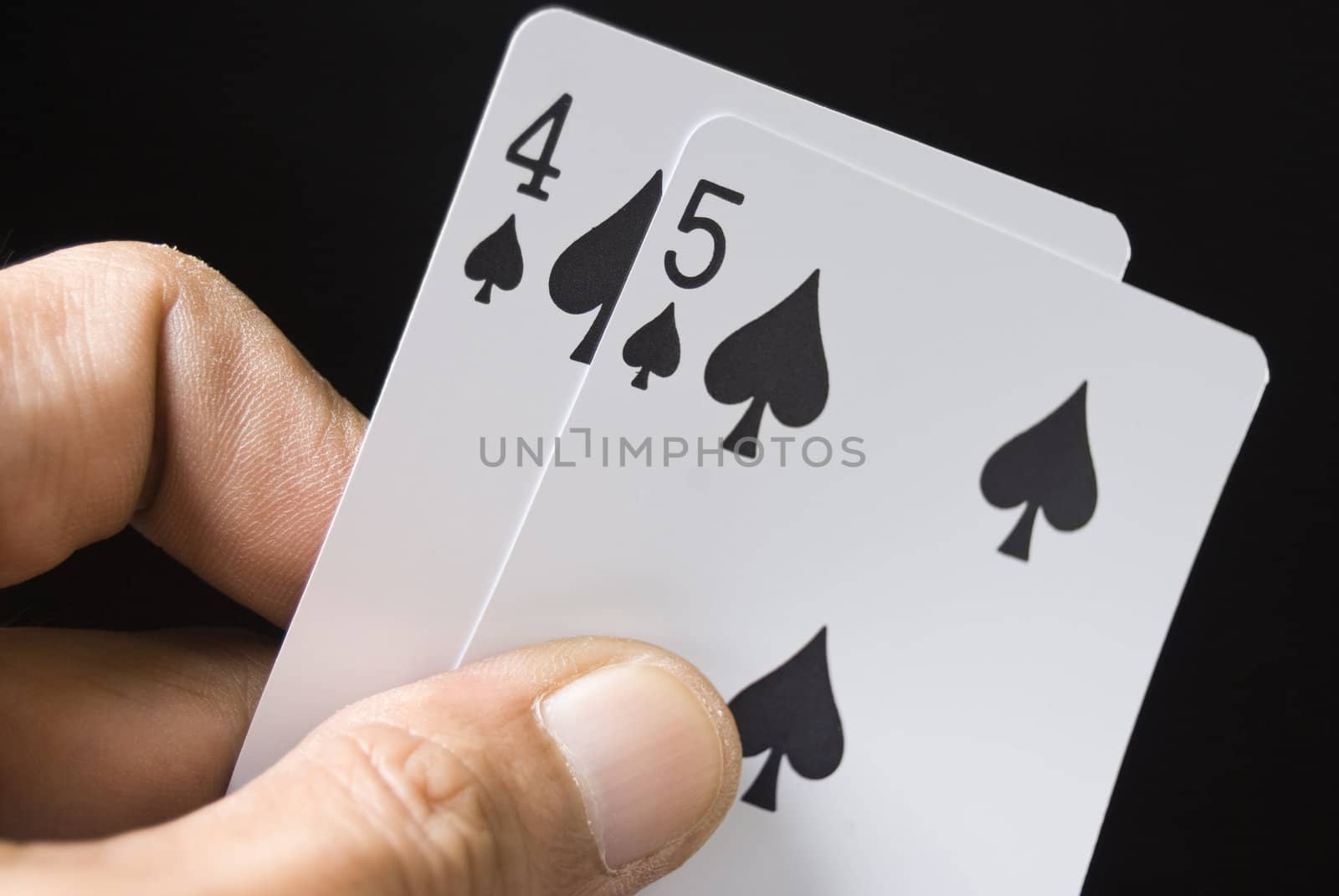 Lucky Nine cards held by hand against black background