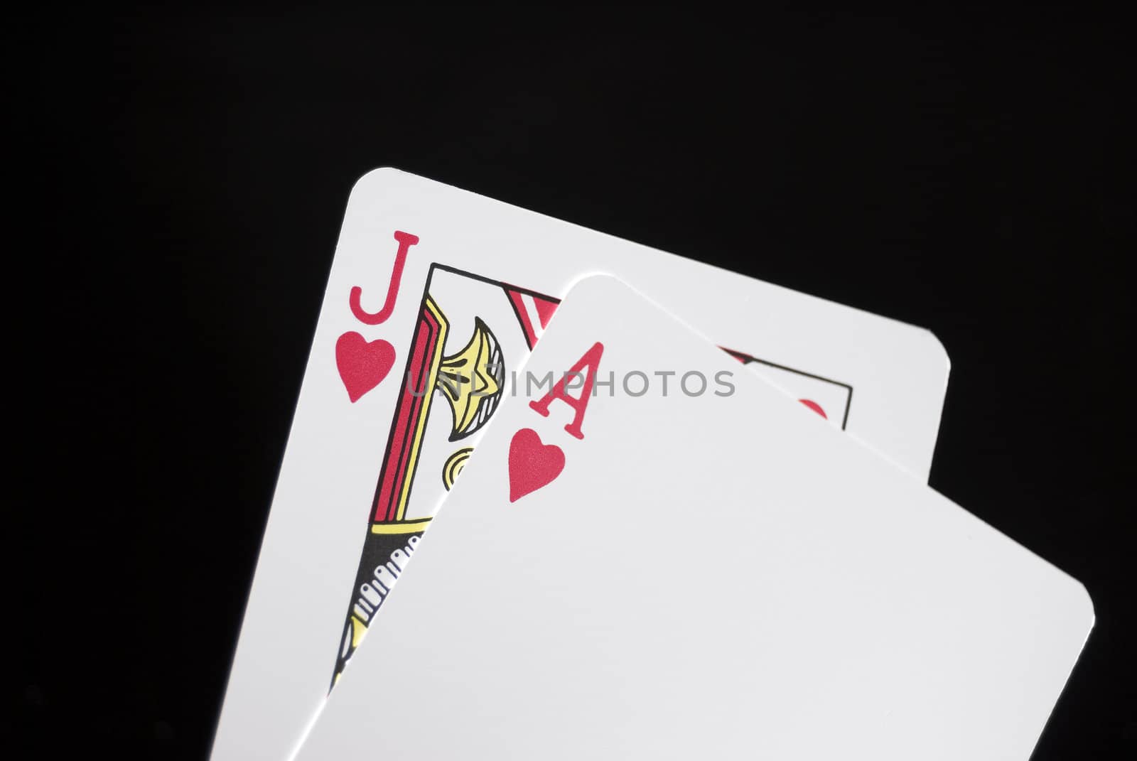 Blackjack cards held by hand against black background