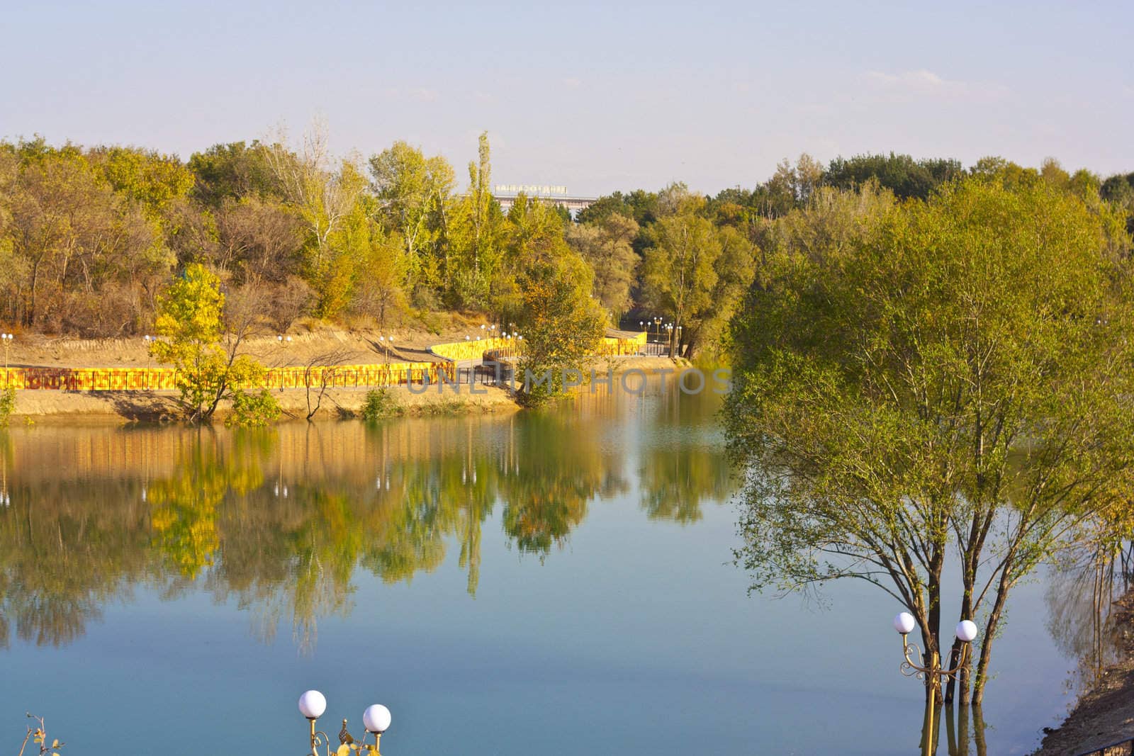 Picturesque autumn landscape of river and bright trees and bushes 