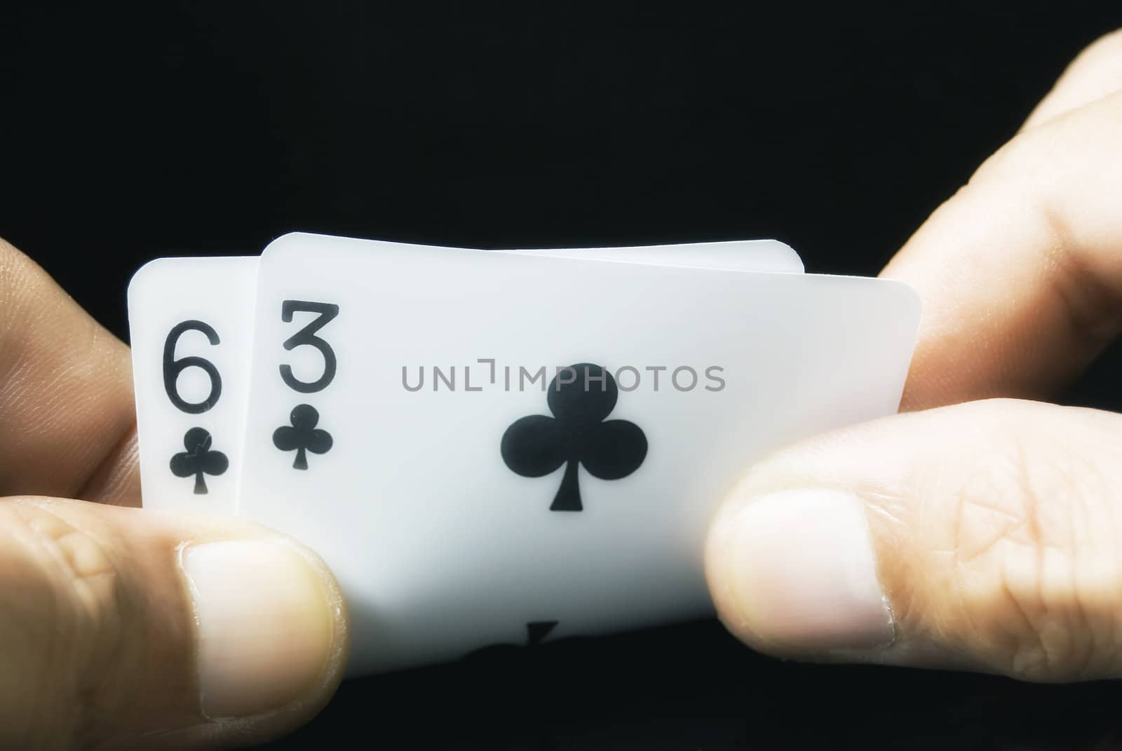 Lucky Nine cards held by hand against black background