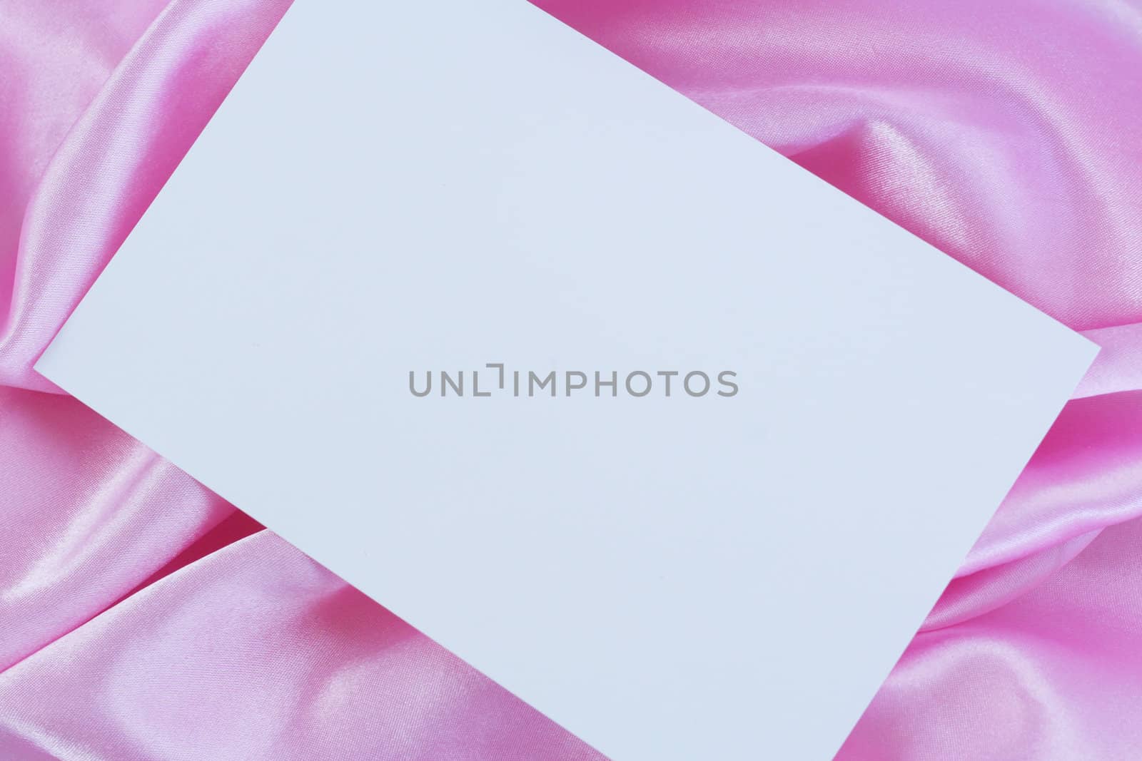 Blank white card on pink satin by jarenwicklund