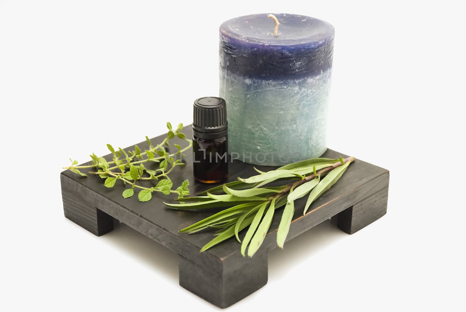 Still life of herbs, mineral oil, and candle