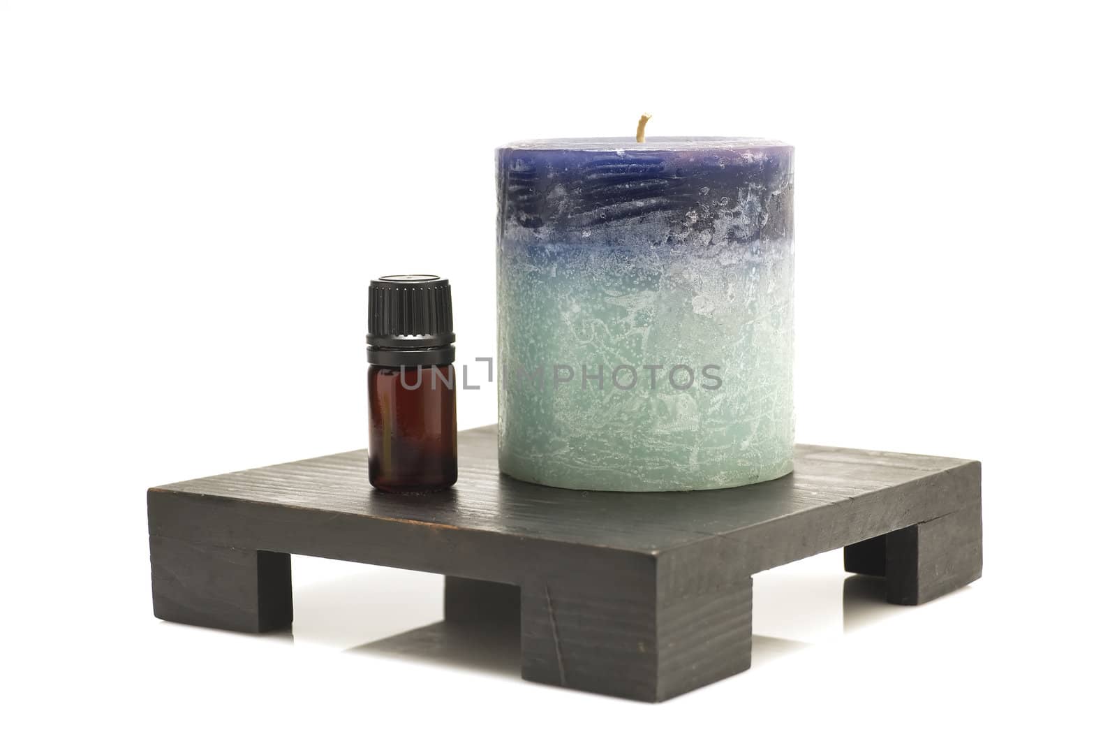 Still life of mineral oil and candle on top of candlestand