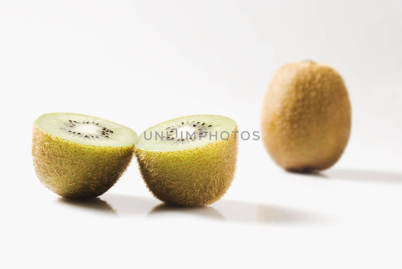 Whole and sliced kiwi fruit on white background
