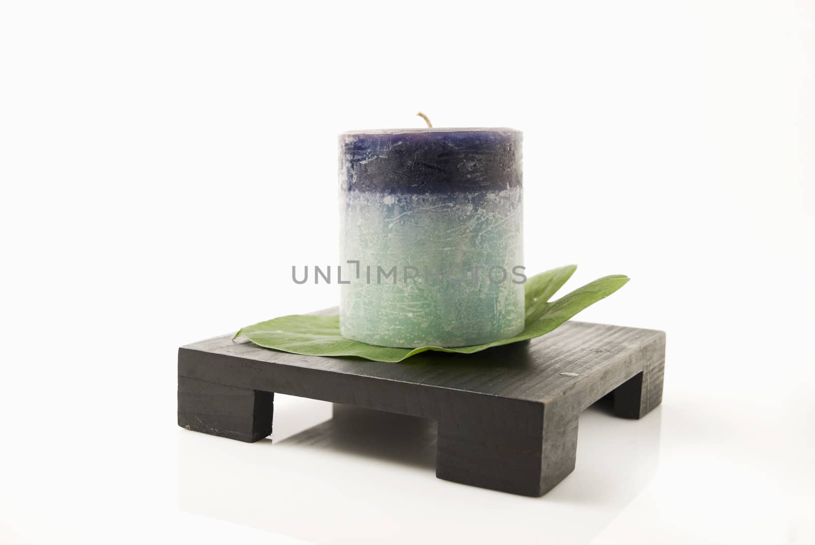 Still life of candle and leaf on wooden candlestand