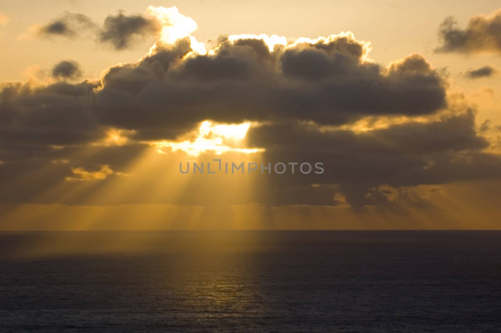 nearing sunset as sunlight shafts through the storm clouds over the Pacific Ocean as if lit by God