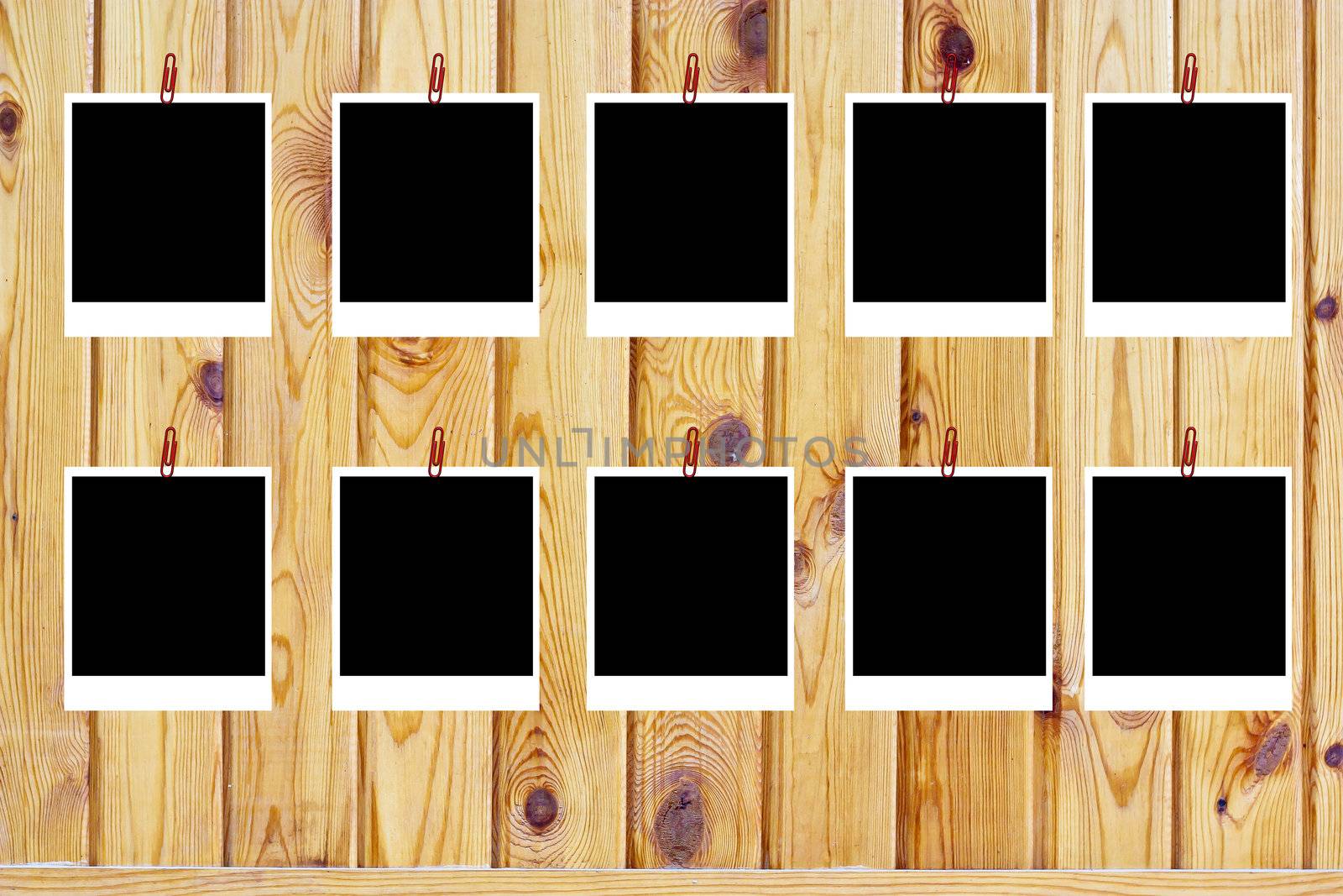 set of ten old blank polaroids frames lying on a wood surface  by schankz