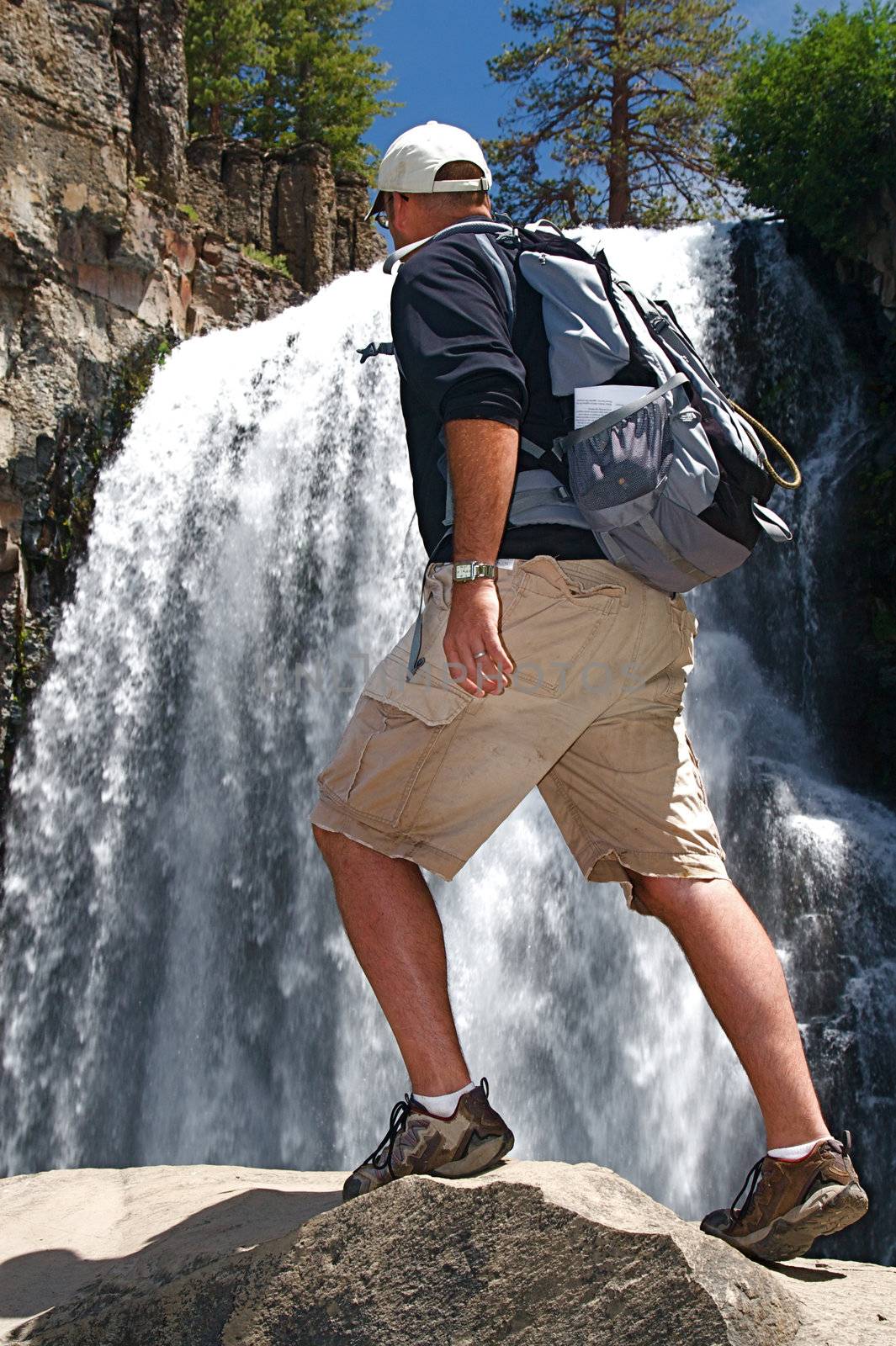 Rugged hiker views the wild terrain at Rainbow Falls in the Devils Postpile NM