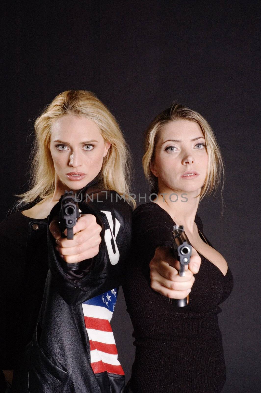 two Sexy woman with guns in leather jacket on a black background