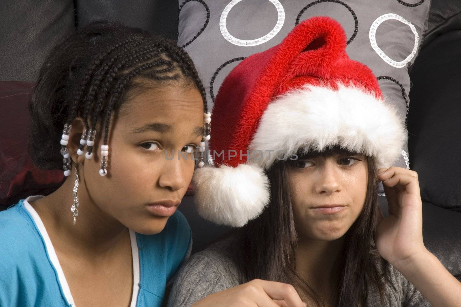 Attractive young girl in a santa hat with african american girlfriend
