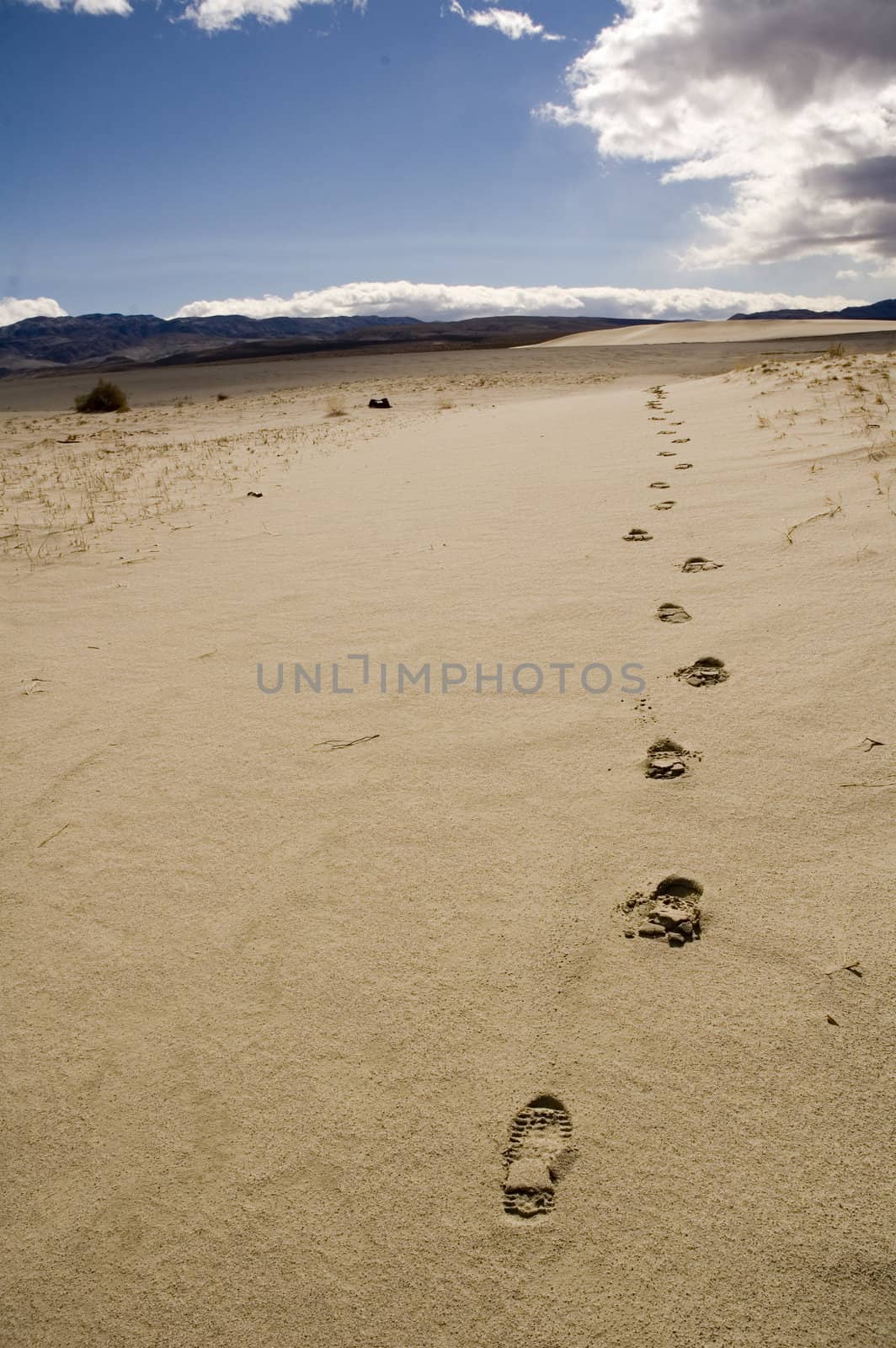 following footprints leading off towards the distant mountains and into the desert in Death Valley