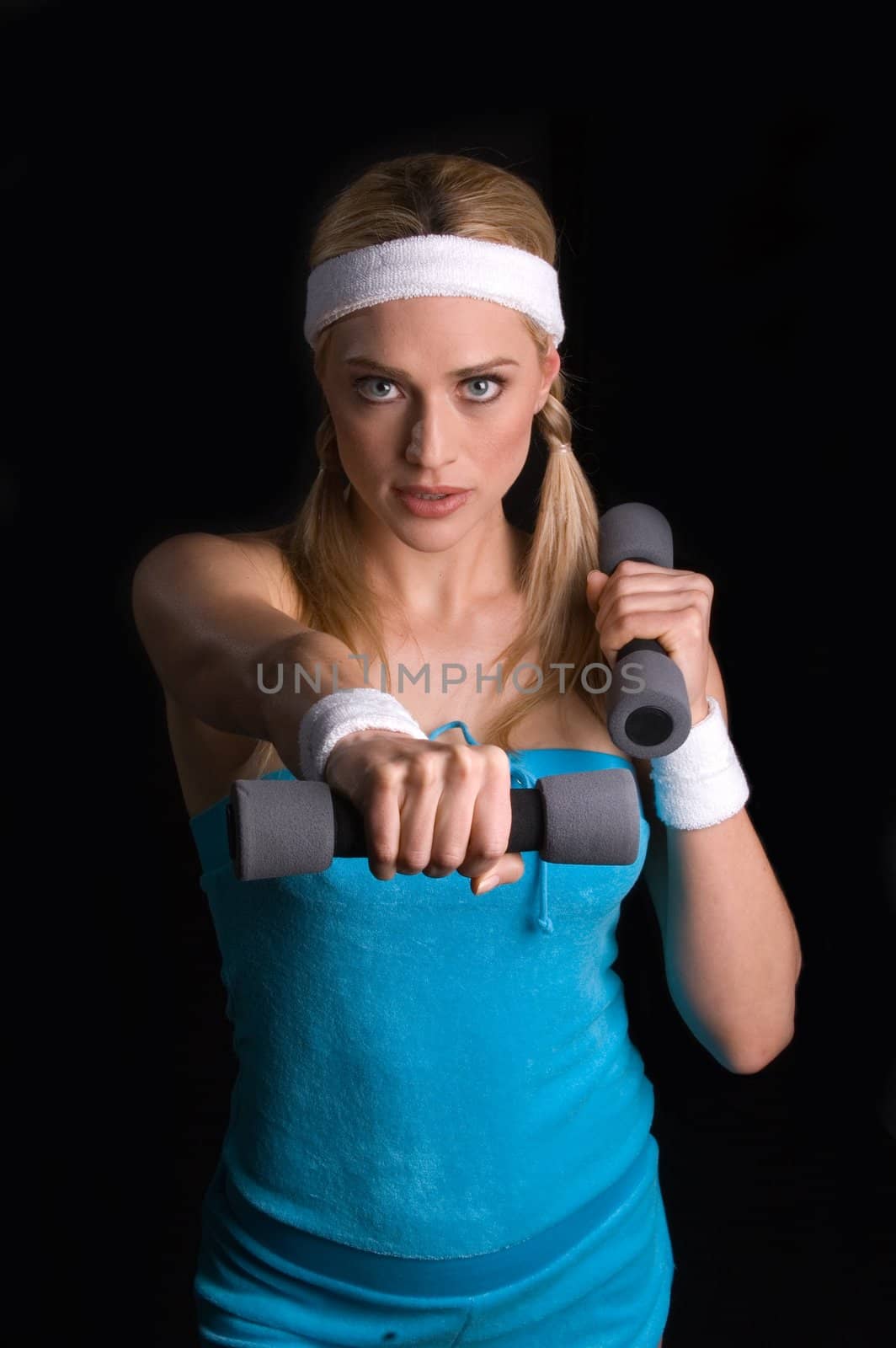 Woman playing raquet ball against a black background