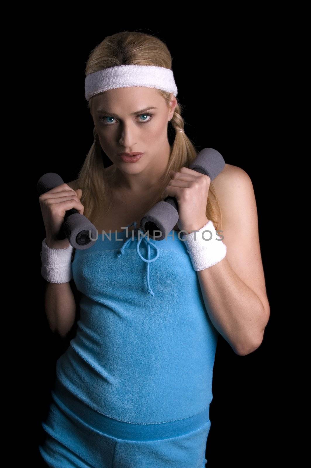Woman exercising with weights over a black background