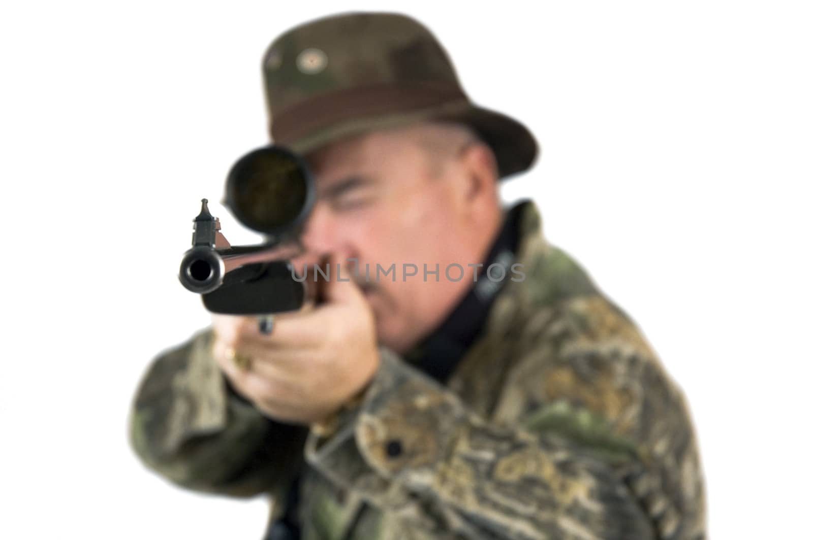 Man in camouflage clothing with rifle taking aim at target