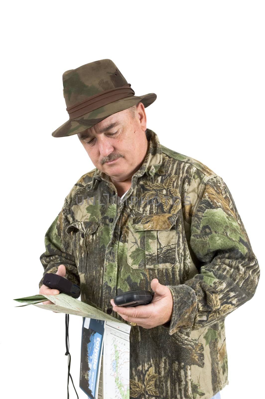 Man in Camouflage clothing using national forest maps and two gps's to check position on a white background