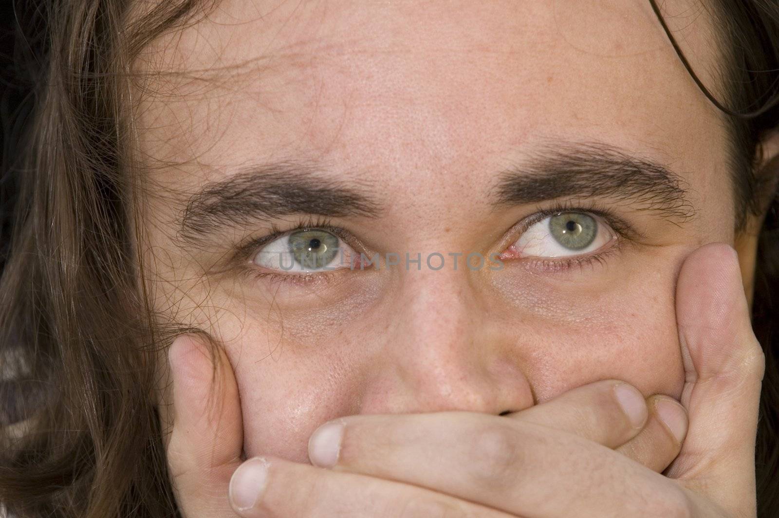 young man with green eyes and beard over black