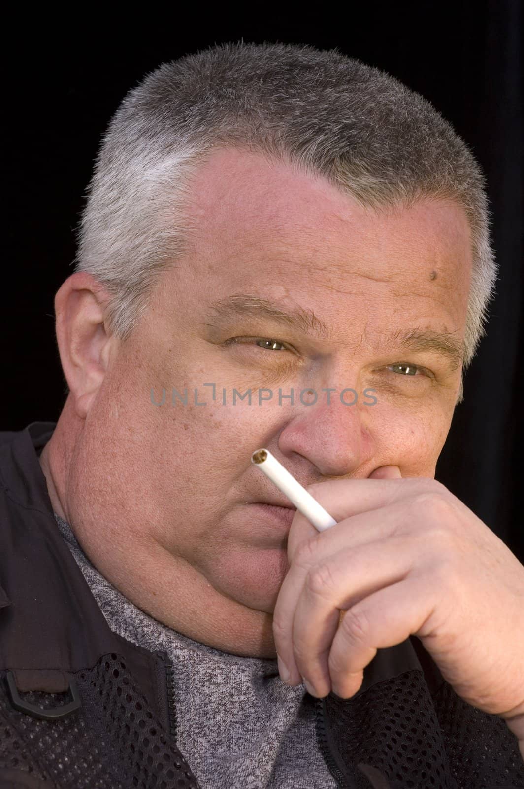 Middle aged man cigarette in hand, thinking about the errors of his ways