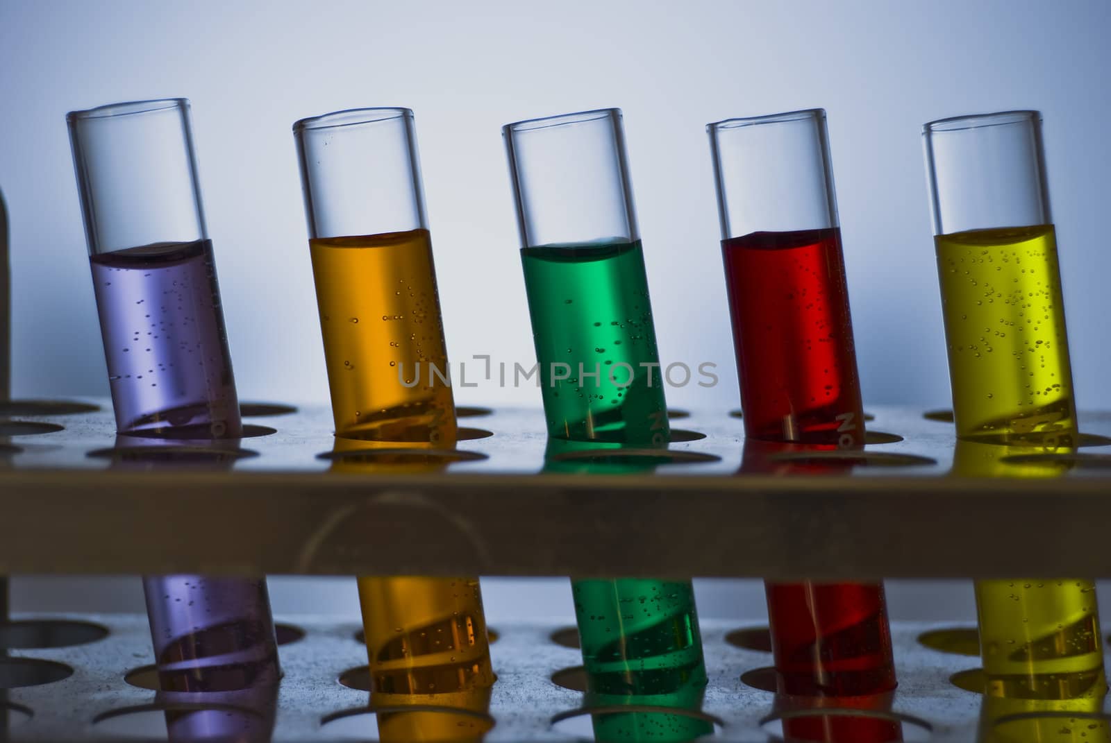 A line of test tubes containing different colored liquids