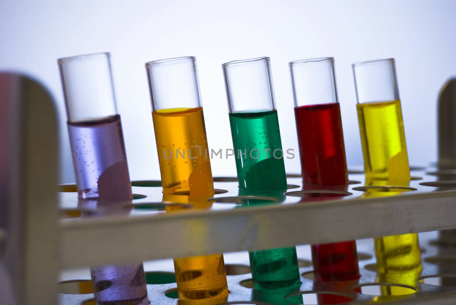 A line of test tubes containing different colored liquids