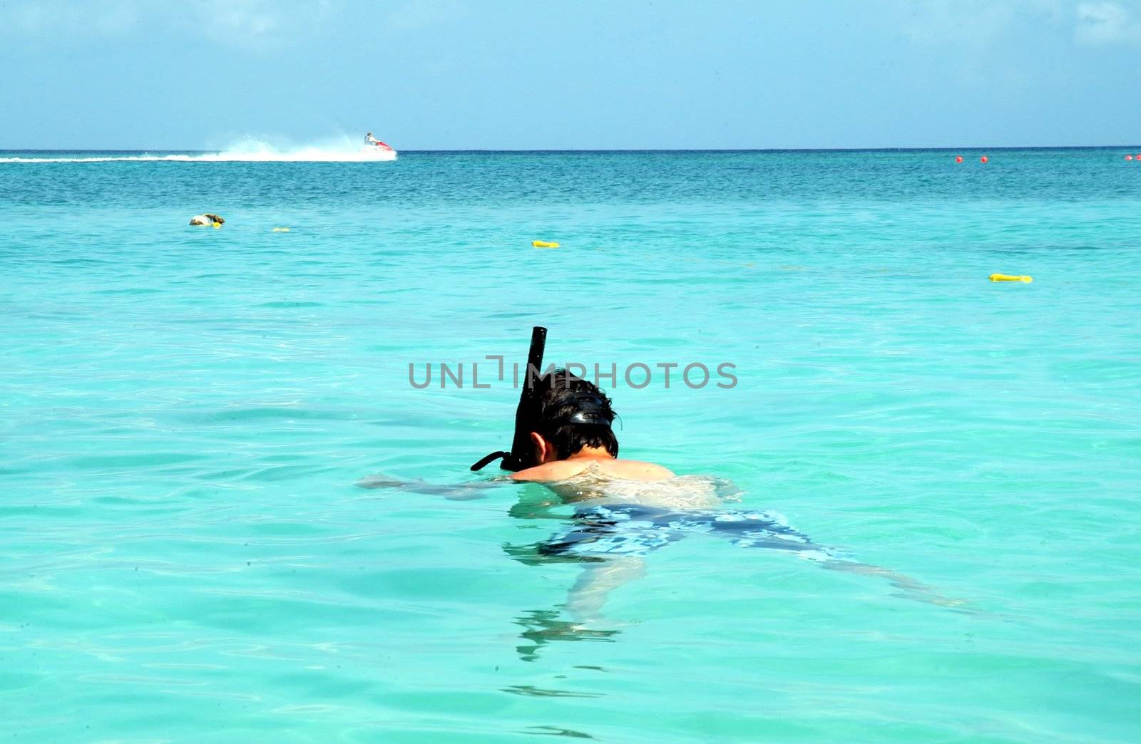 A boy snorkeling in clear water