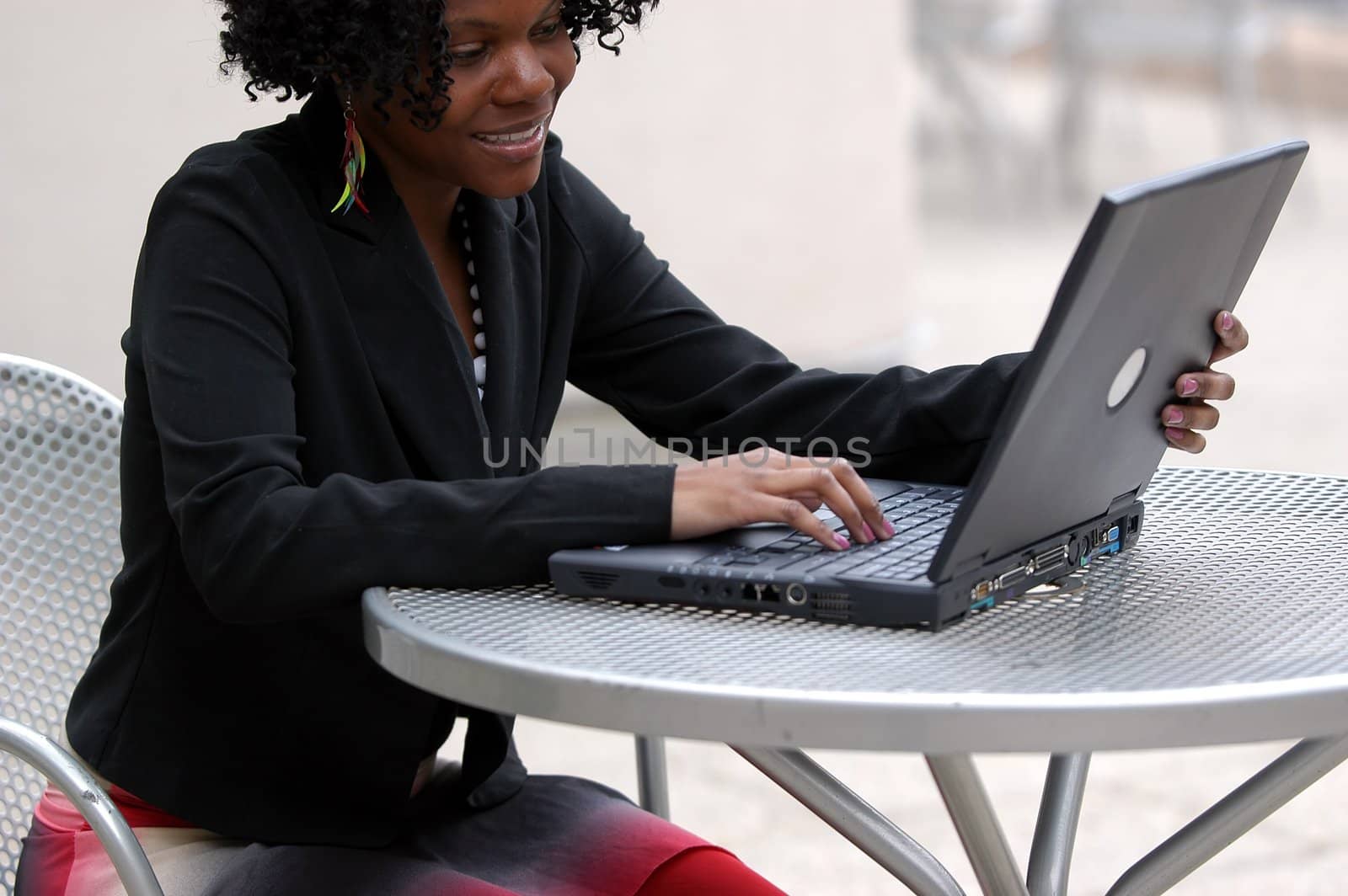 Woman smiles as she looks at the computer.