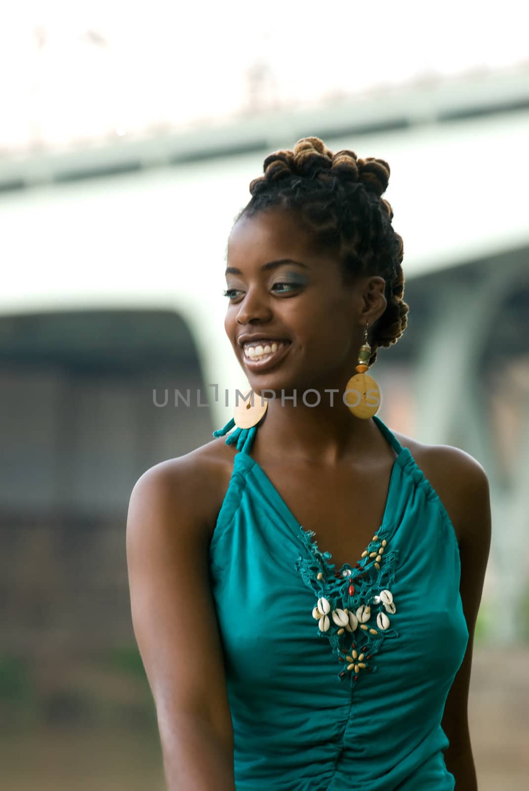african american smiles while sitting by bridge