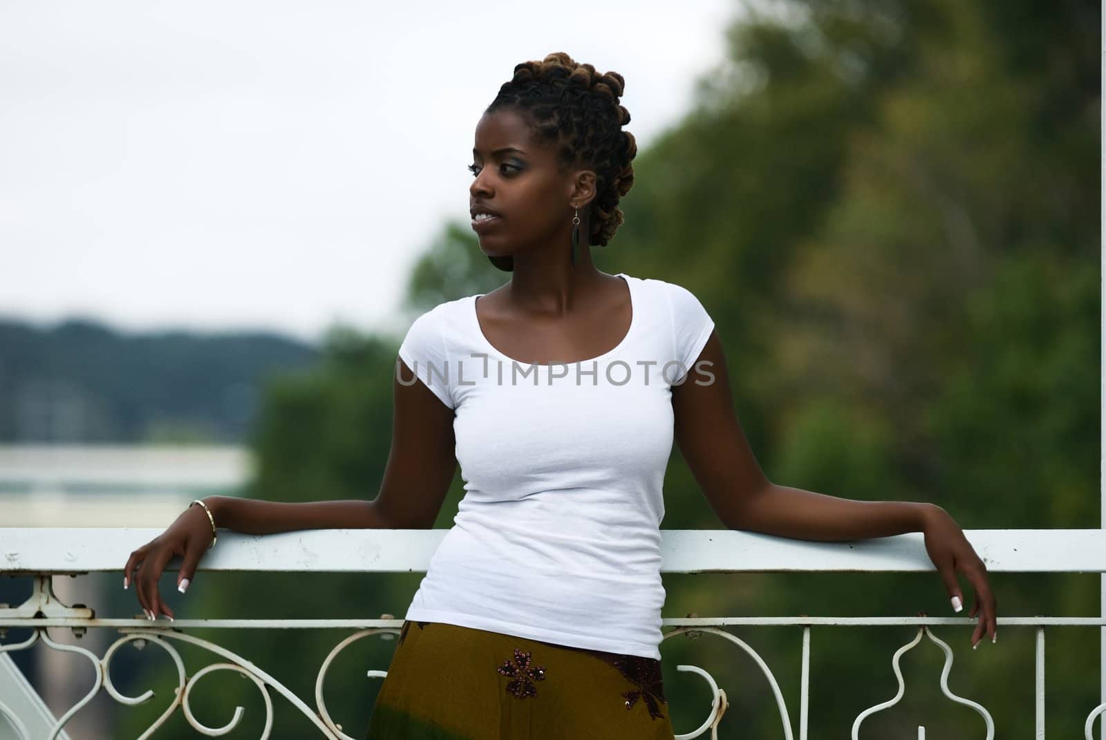 African American woman stands and relaxes on a bridge